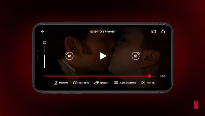 Uma captura de tela de um vídeo da Netflix em um iPhone com um ator e uma atriz se beijando e a guia Momentos na parte inferior.