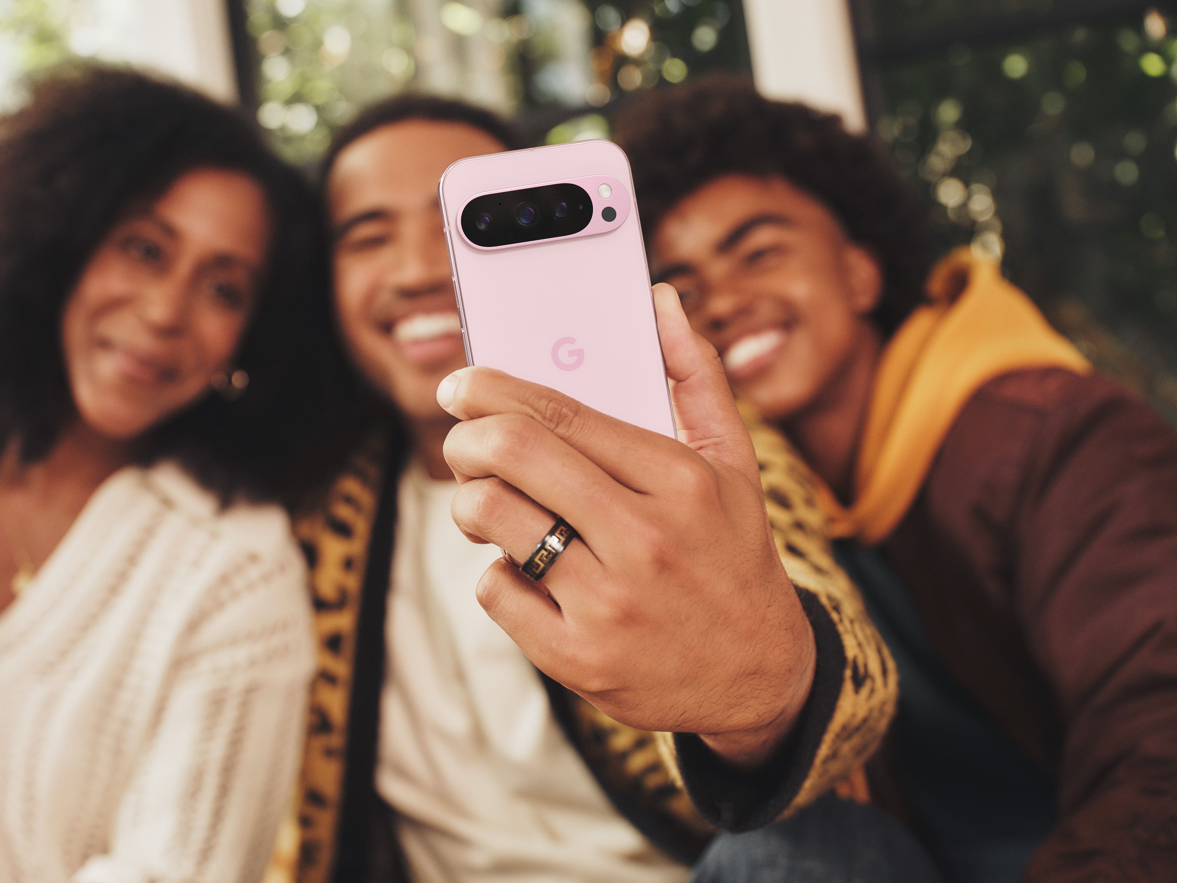 Grupo de pessoas usando o Pixel 9 Pro para tirar uma selfie.