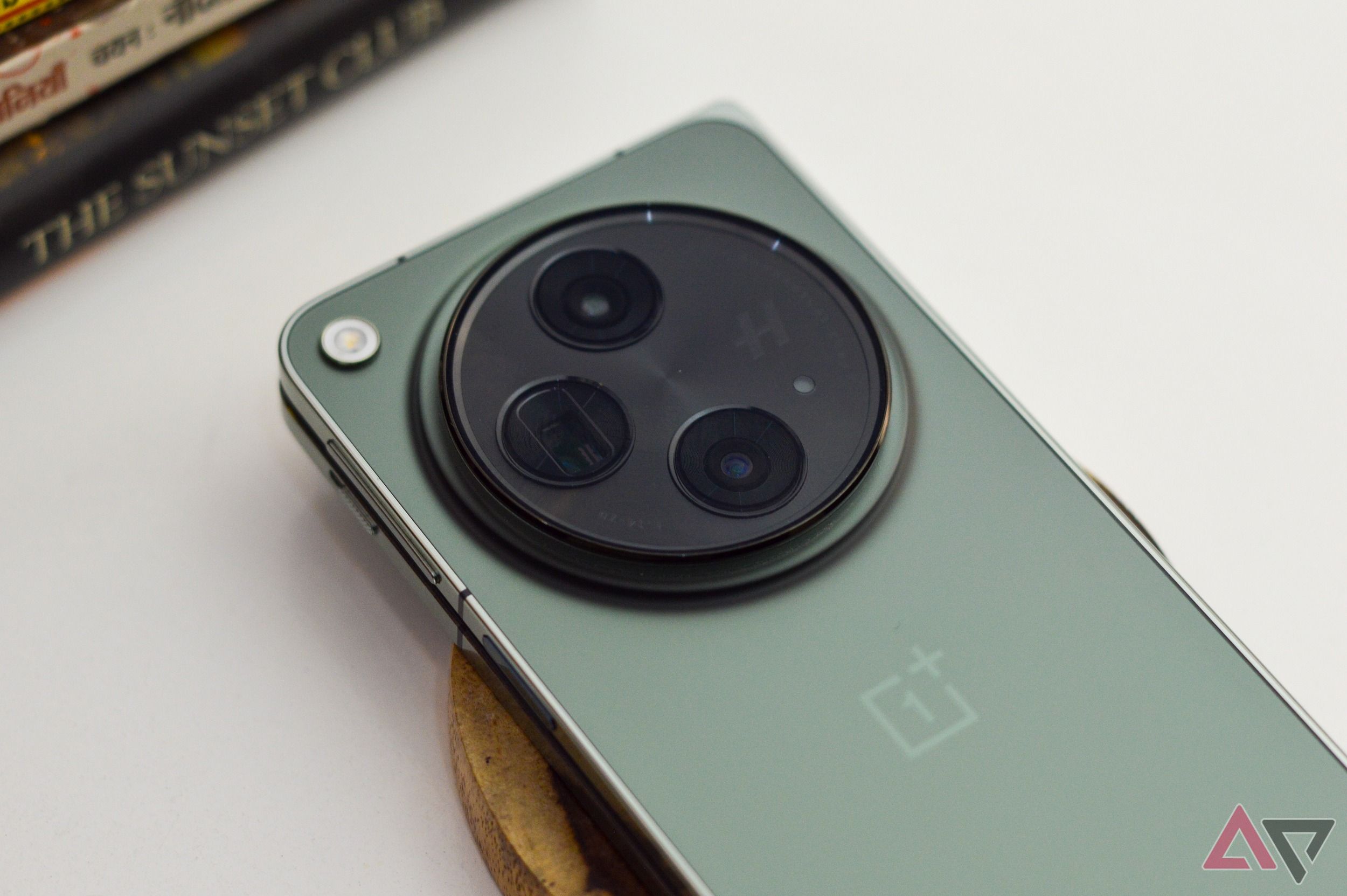 OnePlus Open em Emerald Dusk deitado em um bloco de madeira