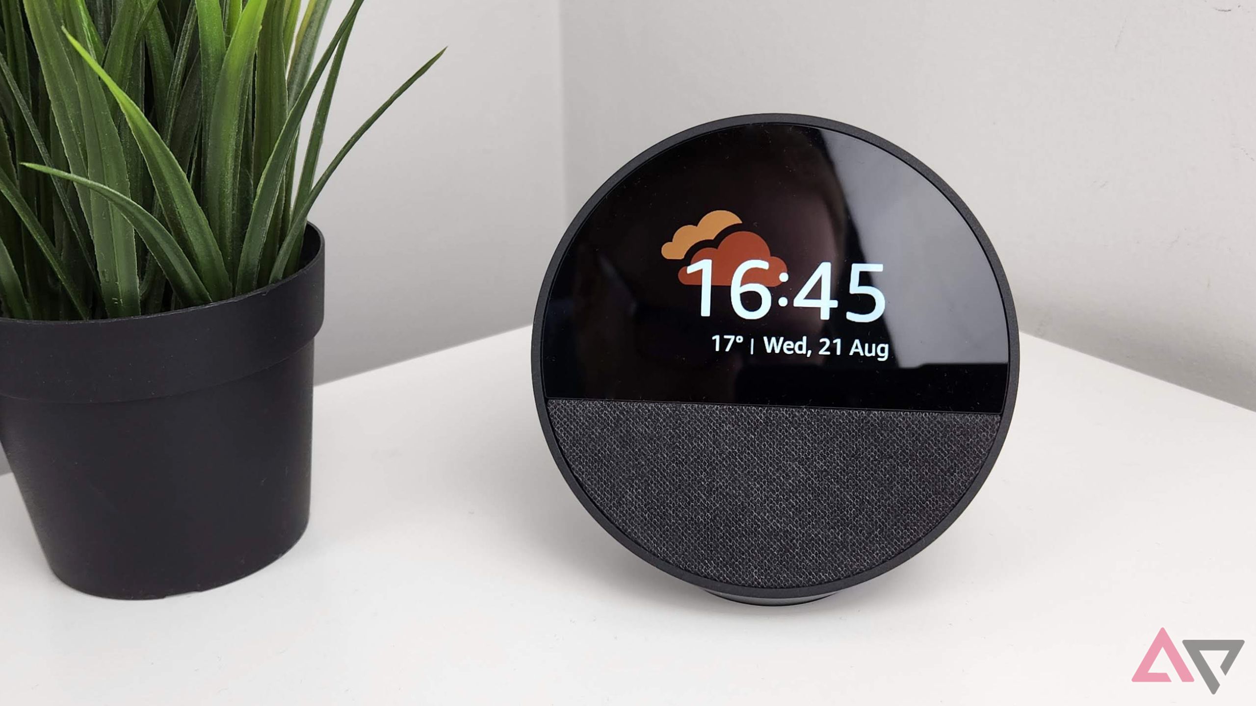 Amazon Echo Spot em uma mesa branca ao lado de uma planta verde