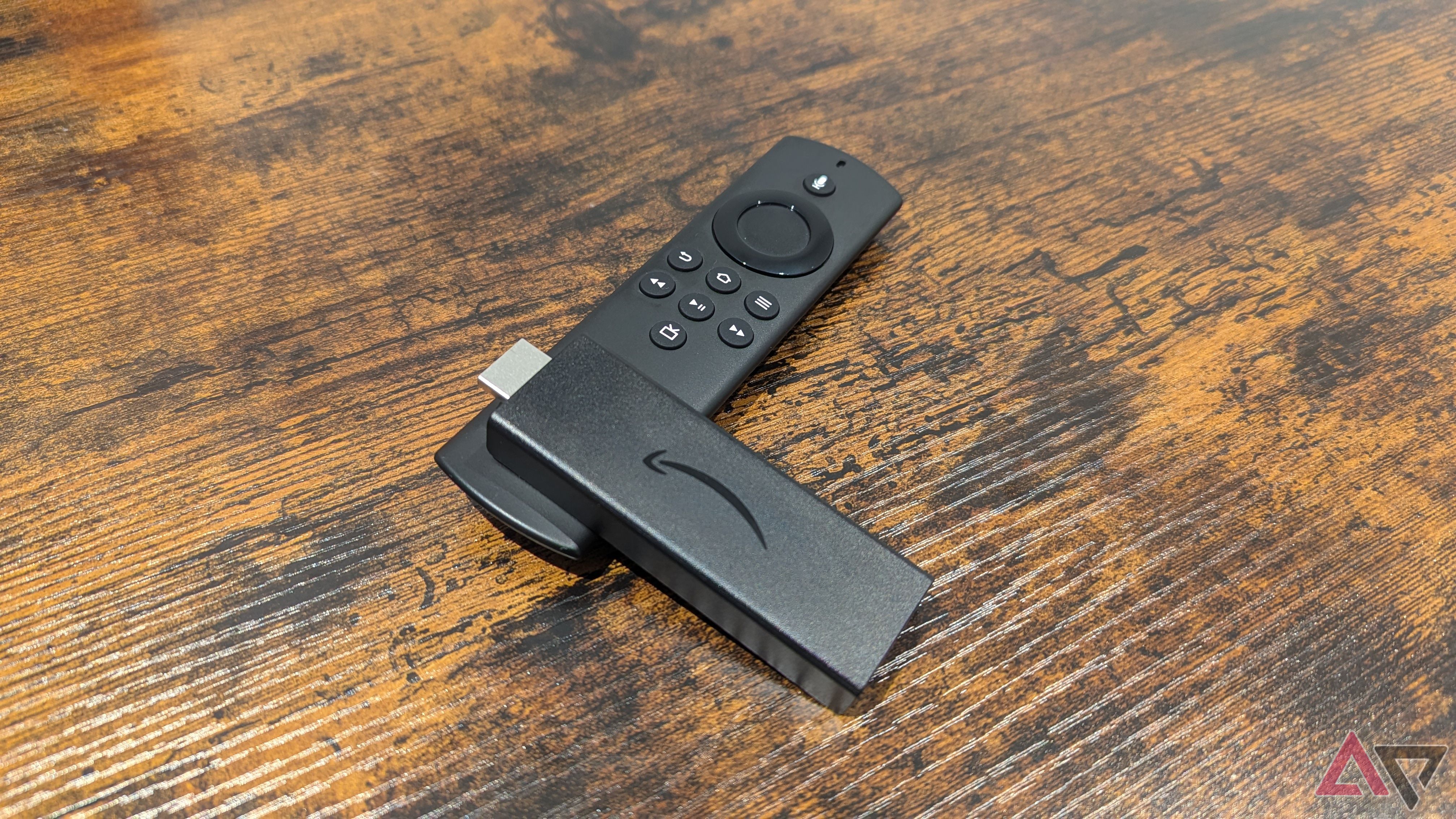 Amazon Fire TV Stick Lite deitado no Alexa Voice Remote Lite em uma mesa de madeira