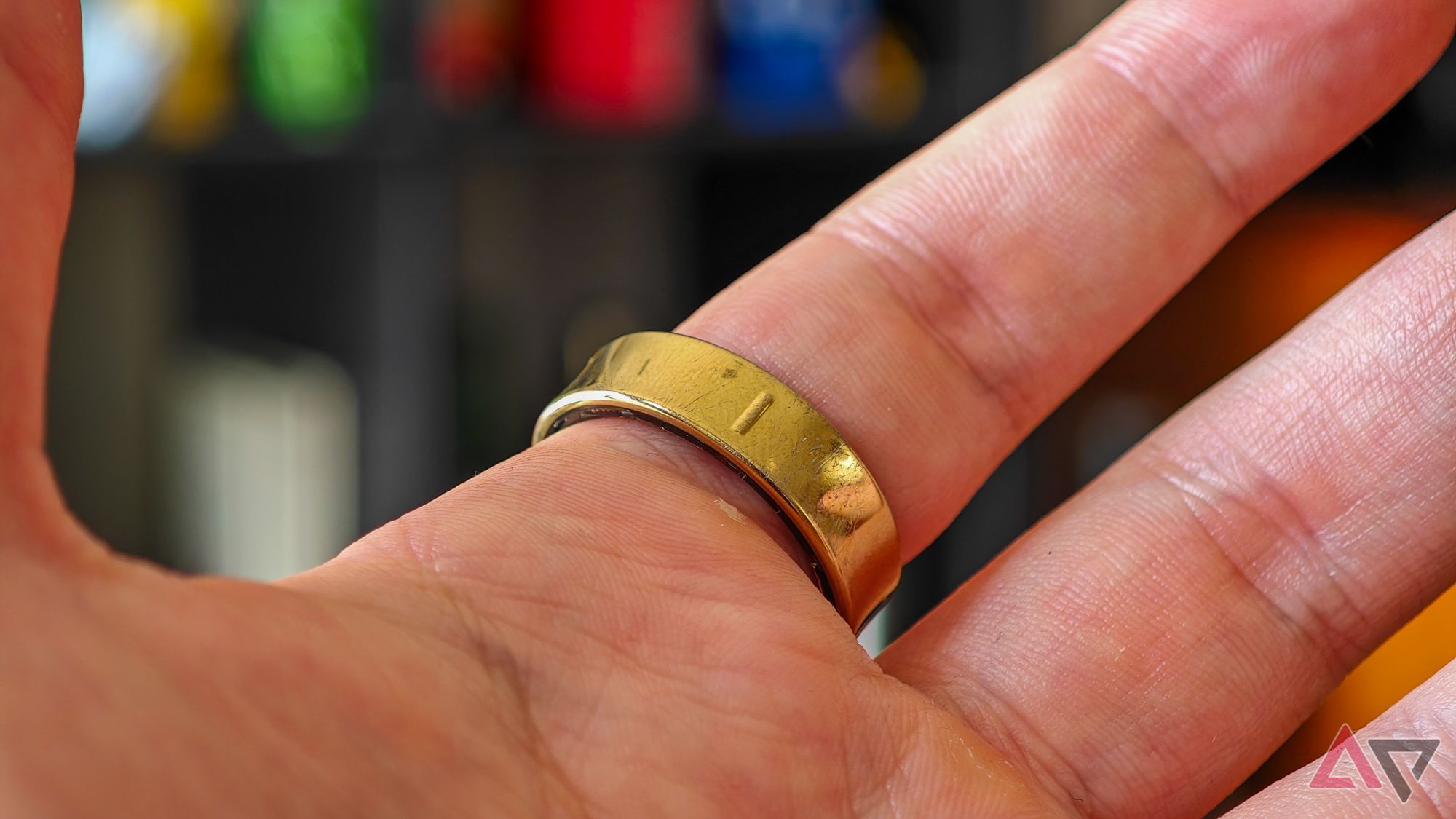 Um Samsung Galaxy Ring dourado no dedo indicador de alguém, tirado da parte inferior para mostrar a crista que marca a parte inferior