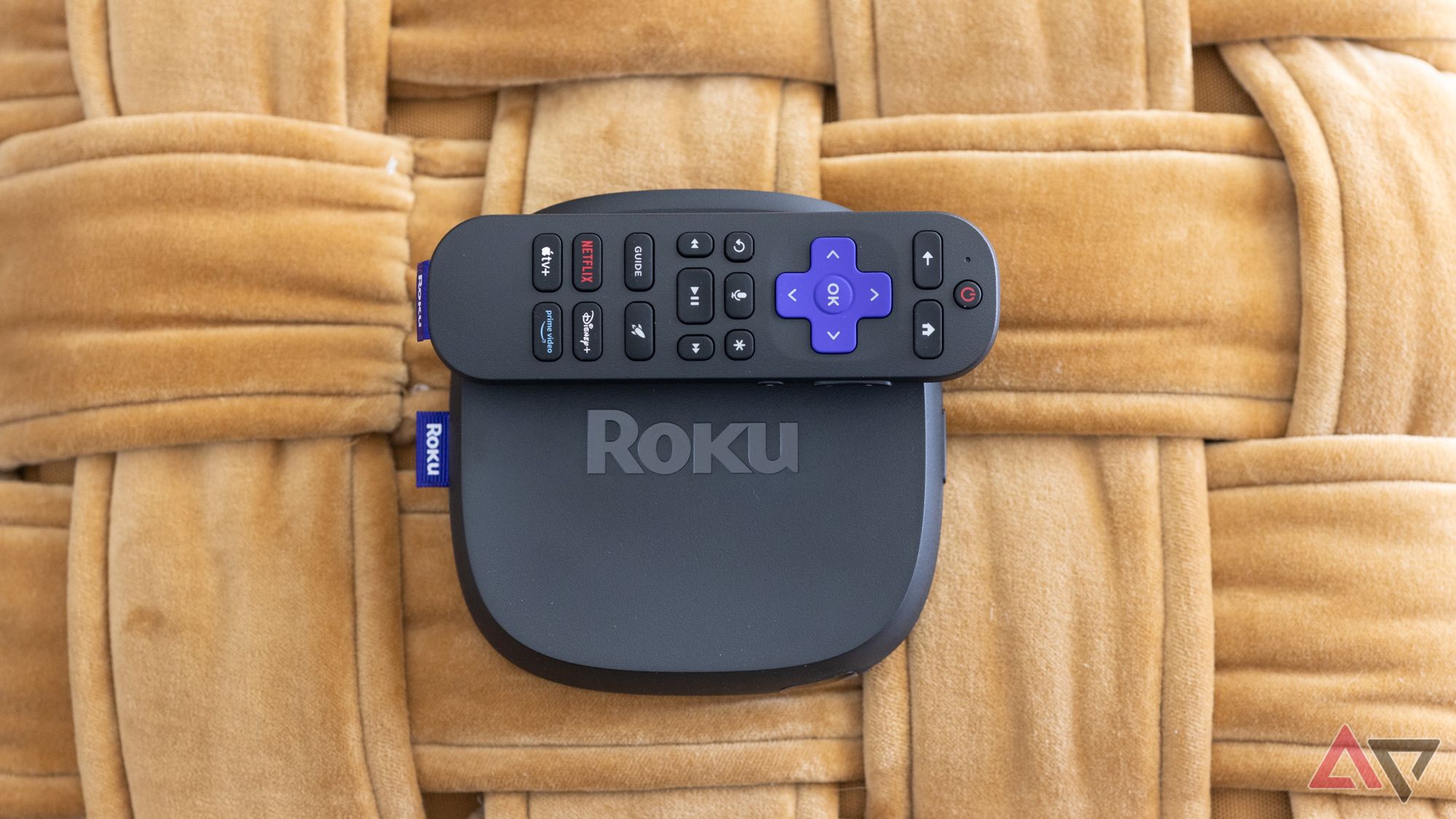 Roku Ultra 2024 Streaming Box e controle remoto em uma superfície tecida