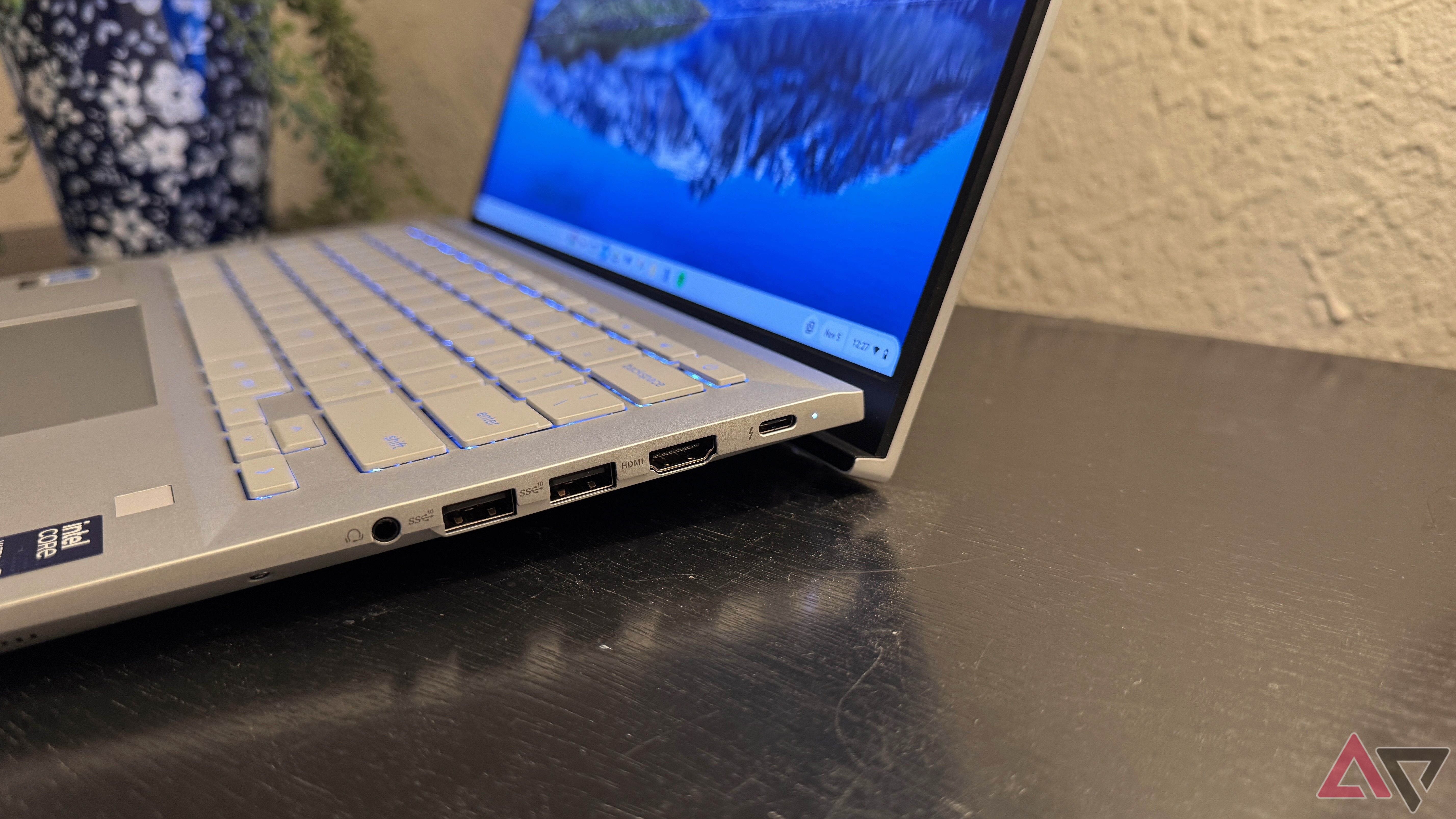 Asus Chromebook Plus CX54 mostrando a dobradiça em uma superfície preta com fundo branco.