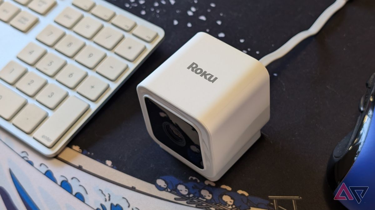 Roku Indoor Camera SE na mesa entre o mouse e o teclado