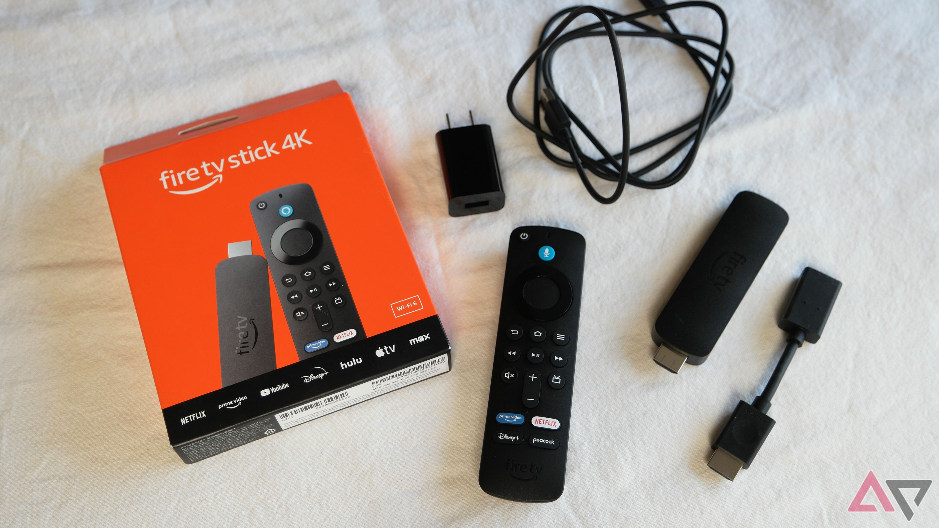 Amazon Fire TV Stick 4K (2ª geração) mostrando a maior parte do que está dentro da caixa. Guia de início rápido não mostrado.