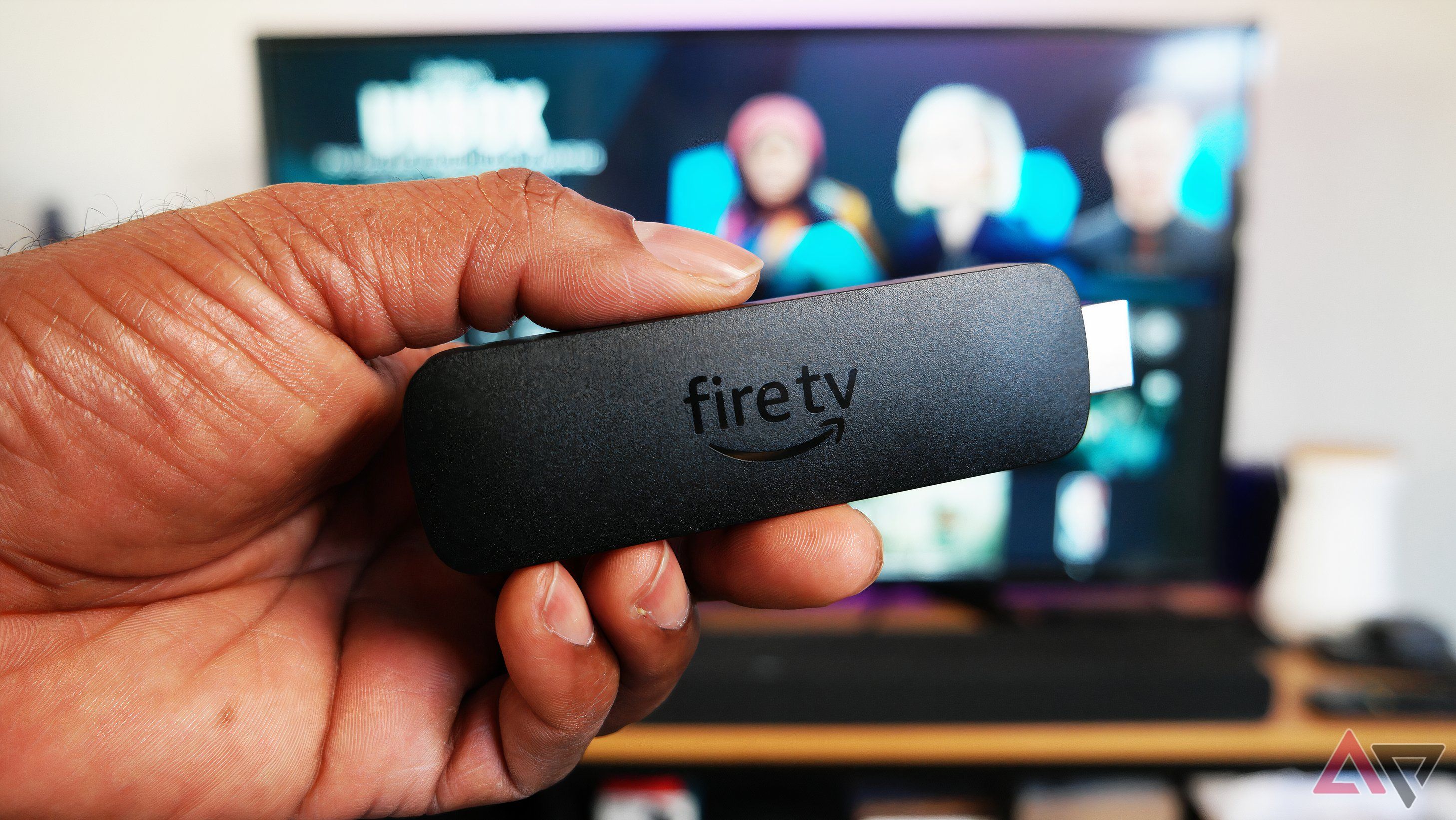 Somente corpo do Amazon Fire TV Stick 4K, mostrado na frente da TV executando Fire OS