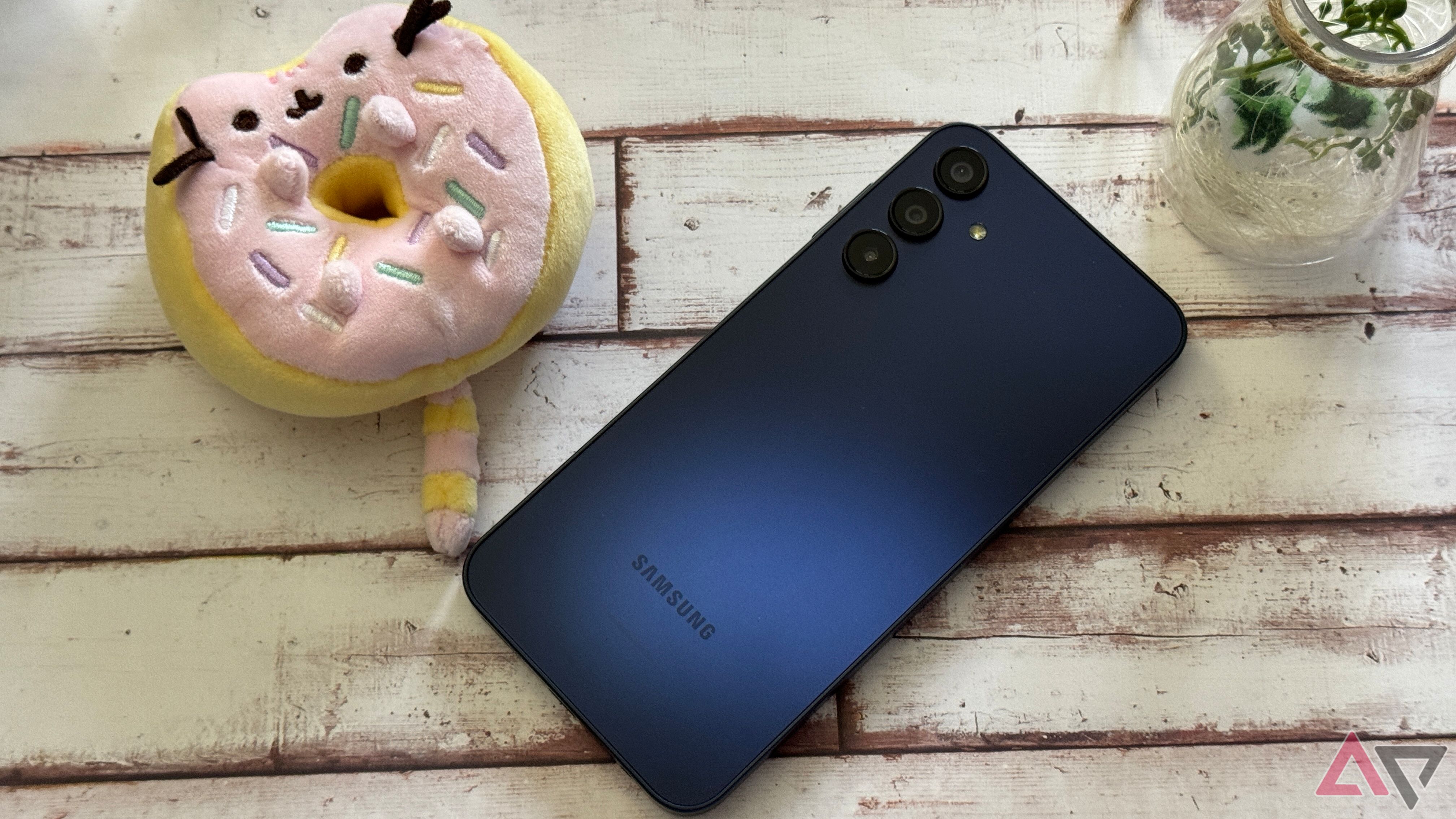 Galaxy A15 deitado em um fundo de madeira com um Pusheen