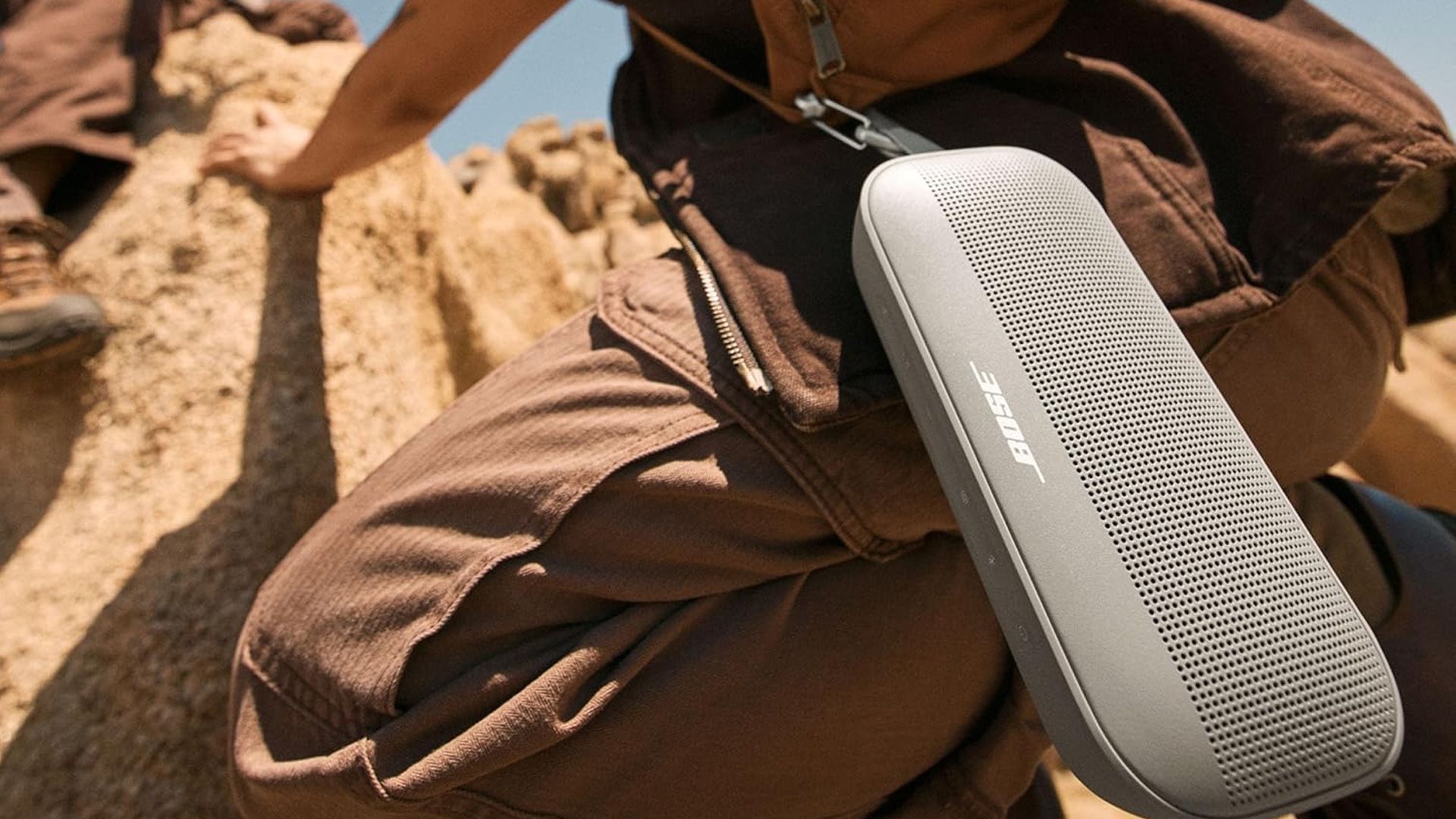 O Bose SoundLink Flex preso à mochila de um caminhante.