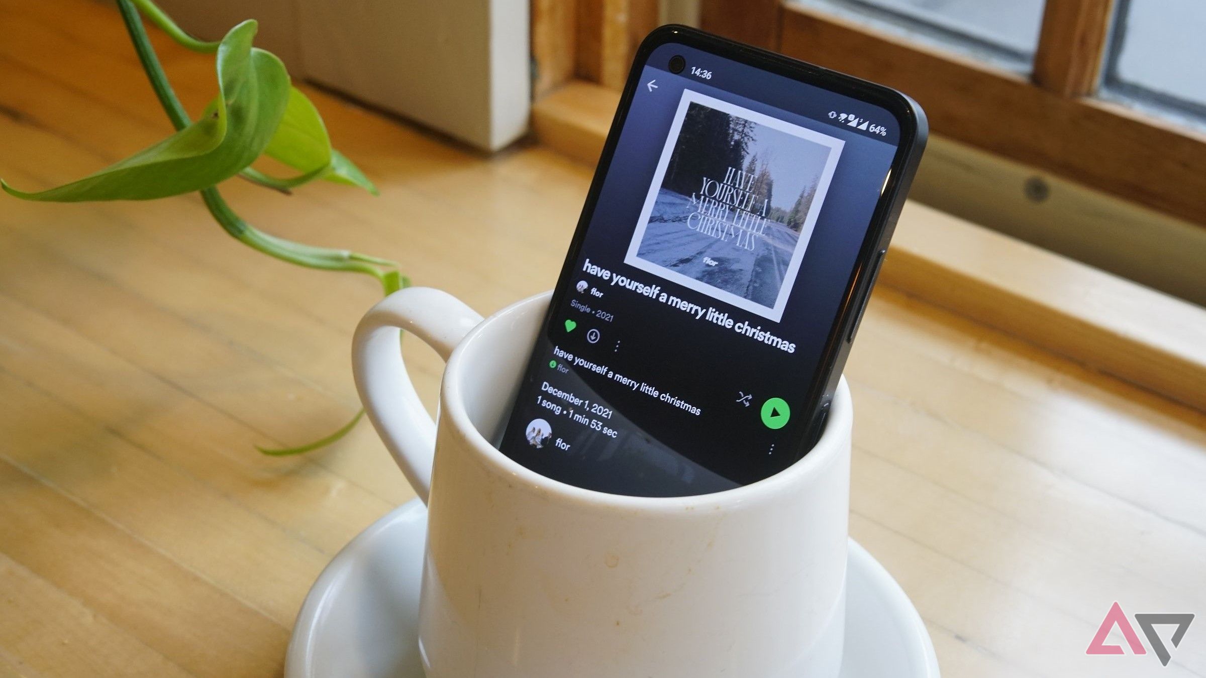 spotify na tela do telefone enquanto Phoe senta em uma xícara de café