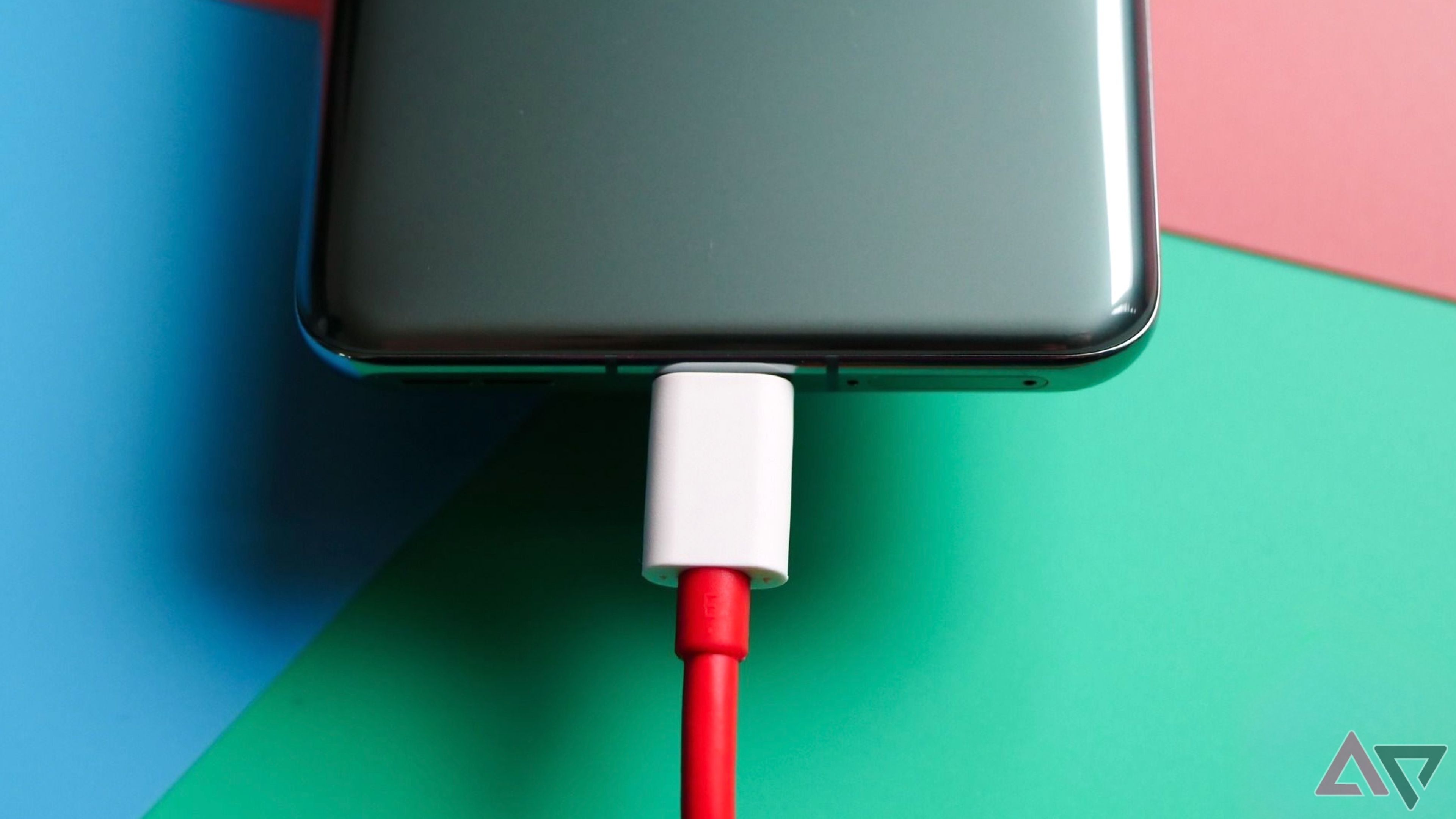 OnePlus 11 conectado a um cabo USB C vermelho