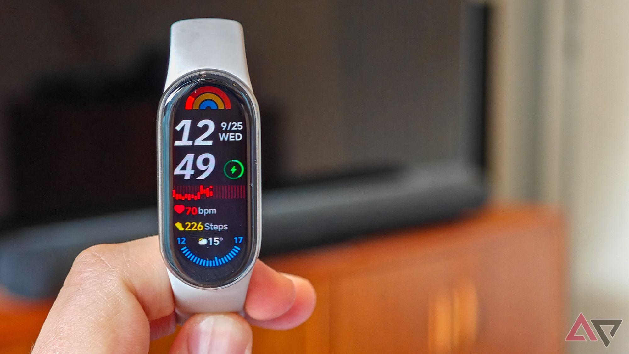 Xiaomi Smart Band 9 em uma tela inicial em frente a uma TV