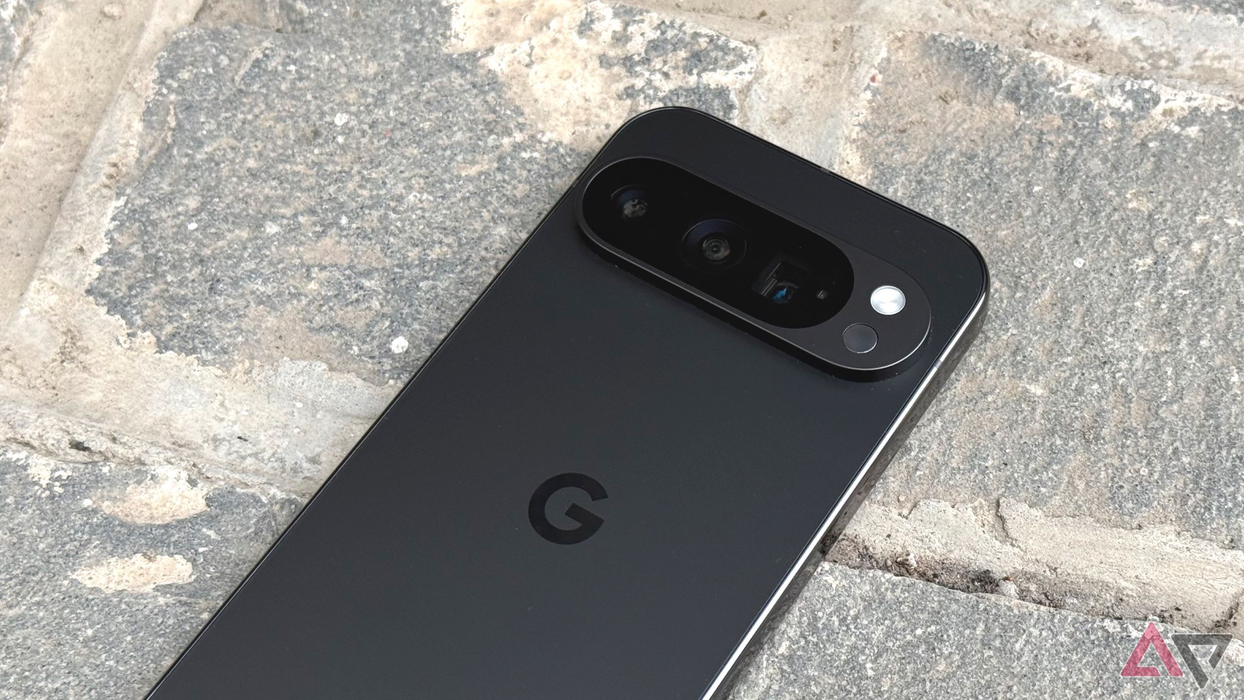 Um smartphone Google Pixel 9 Pro com câmera e fundo de pedra