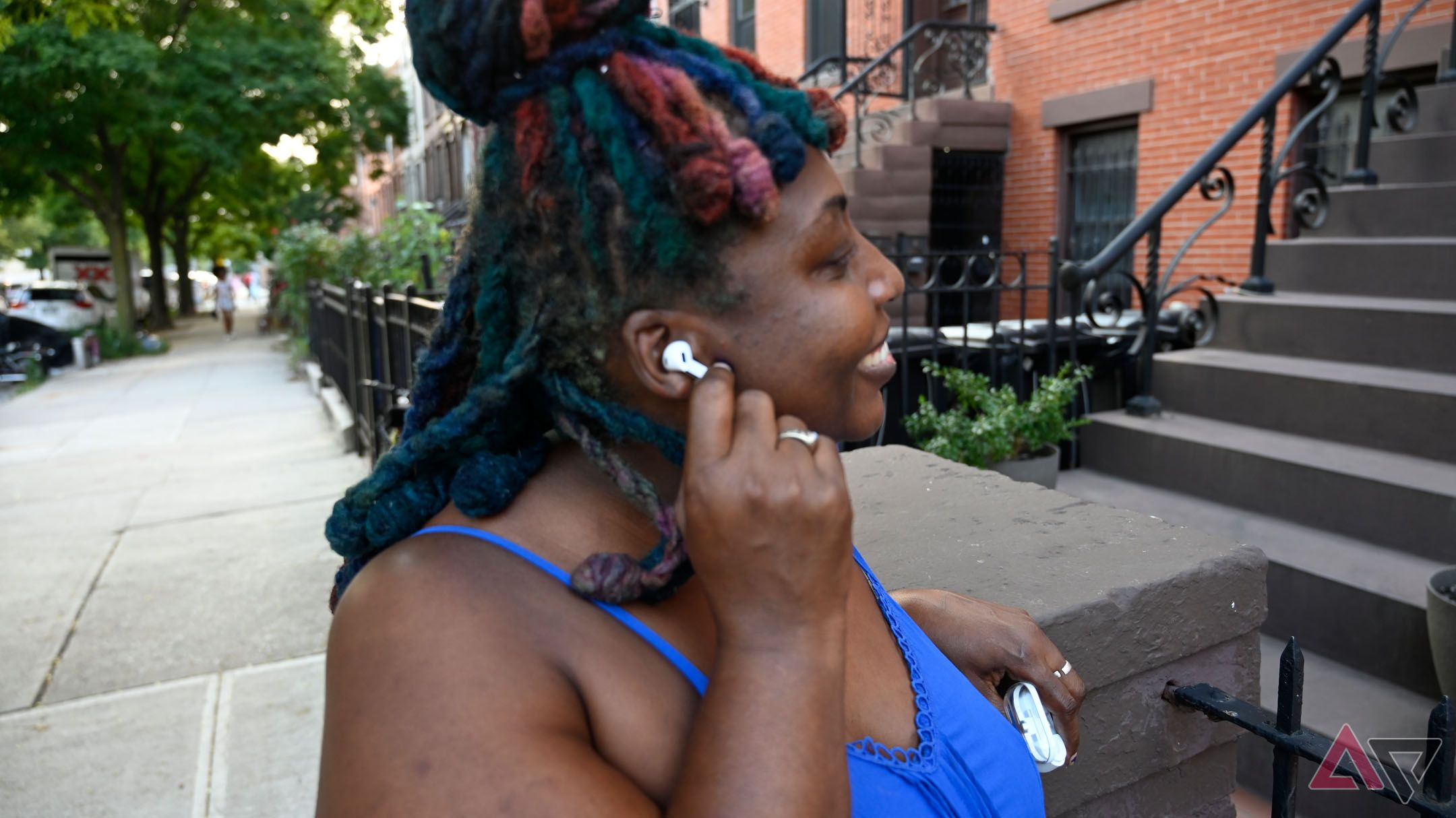 Mulher afro-americana usando os controles de pinça do Samsung Galaxy Buds 3