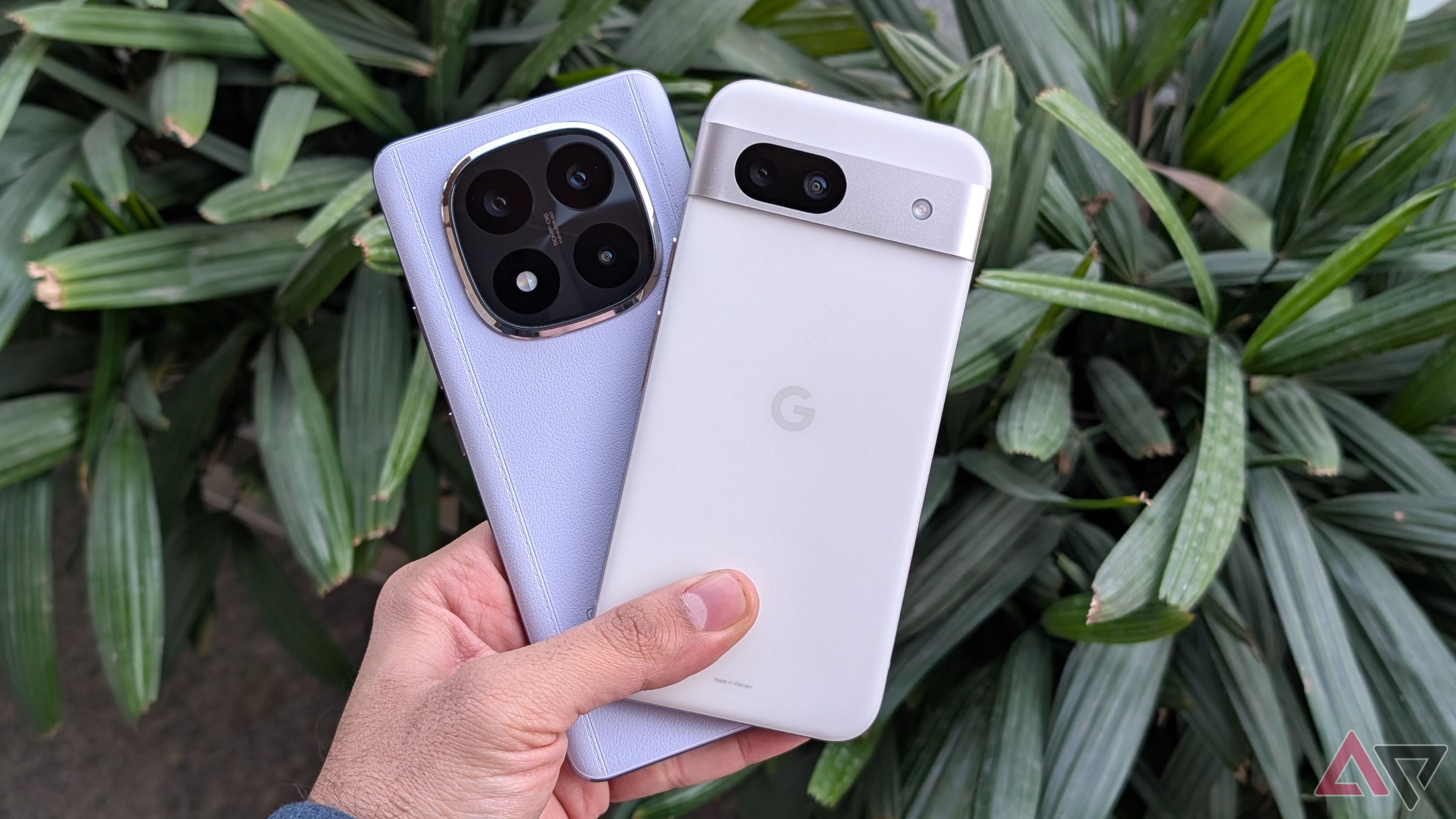 Pixel 8a e Xiaomi Redmi Note 14 Pro+ em mãos em frente a plantas verdes