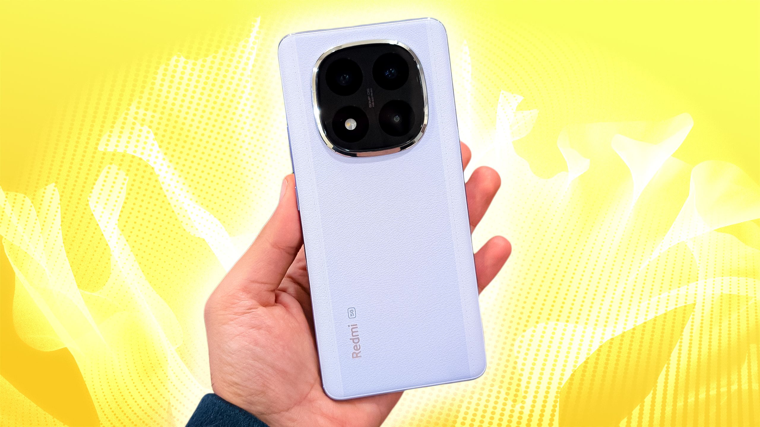 Um telefone de gama média Xiaomi Redmi Note 14 Pro+ segurado na mão contra um fundo amarelo