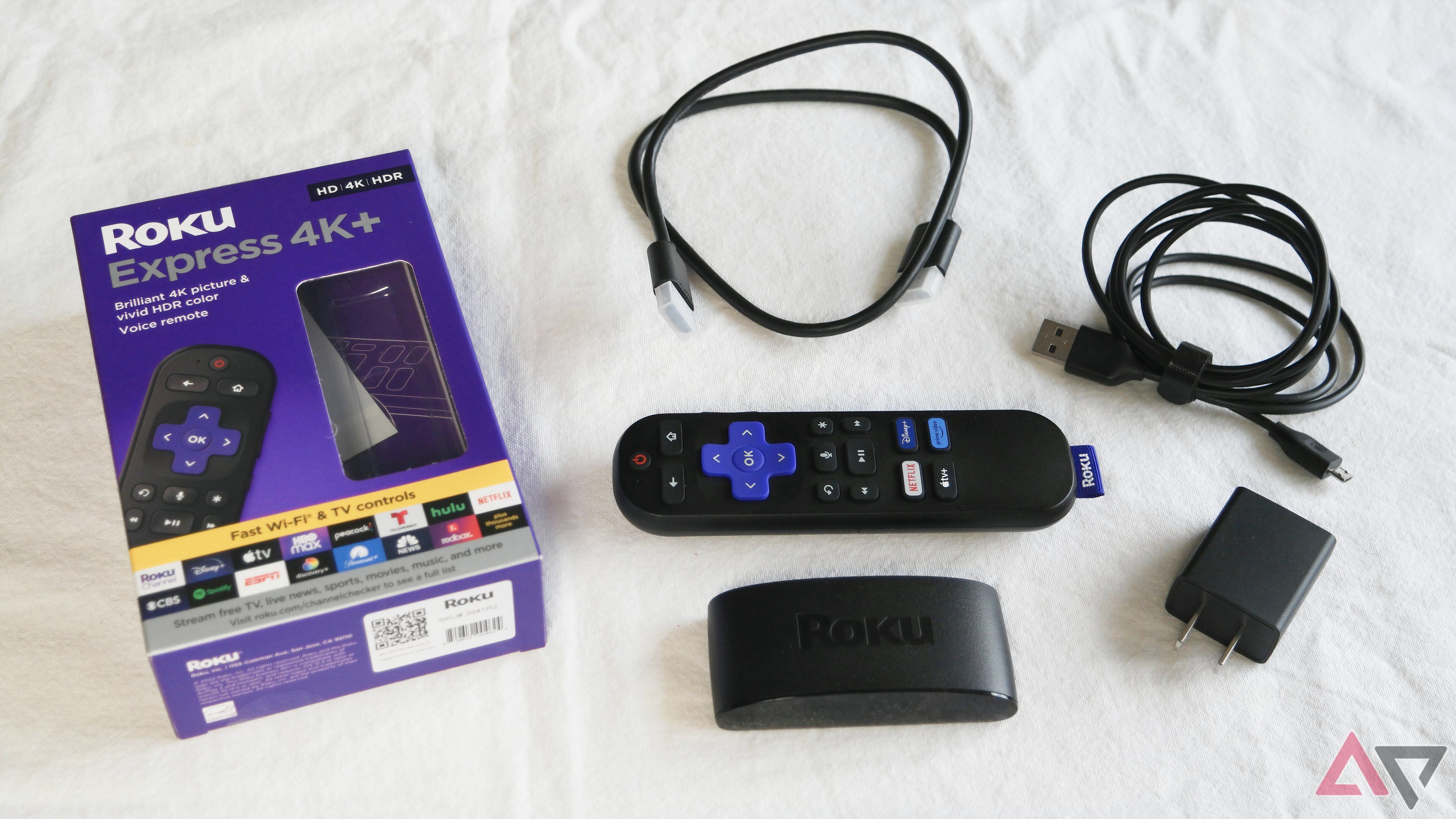 O Roku Express 4K + sem caixa, todos os componentes dispostos sobre uma mesa