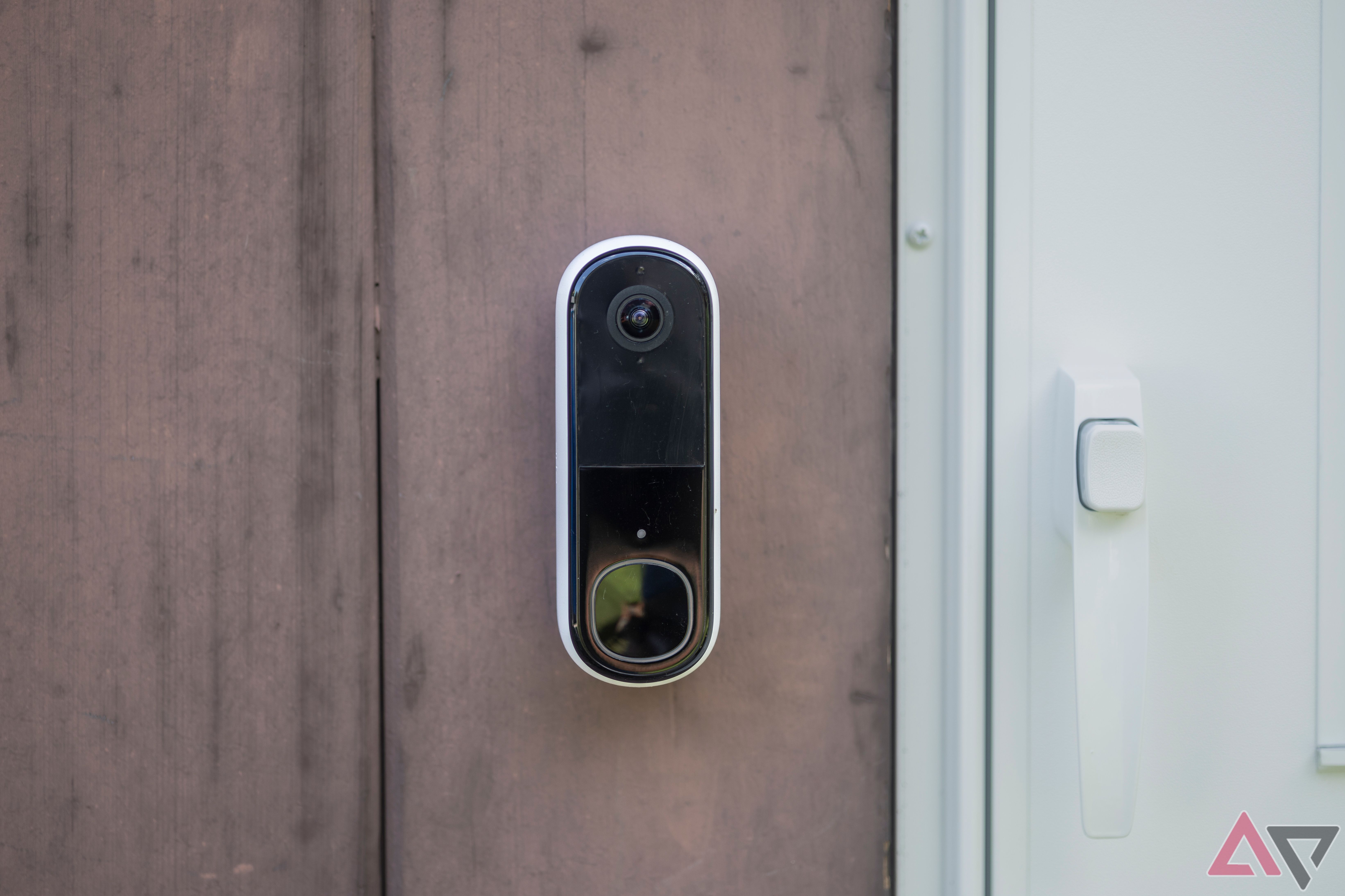 Arlo Video Doorbell (2ª geração, 2K) montada ao lado da porta branca