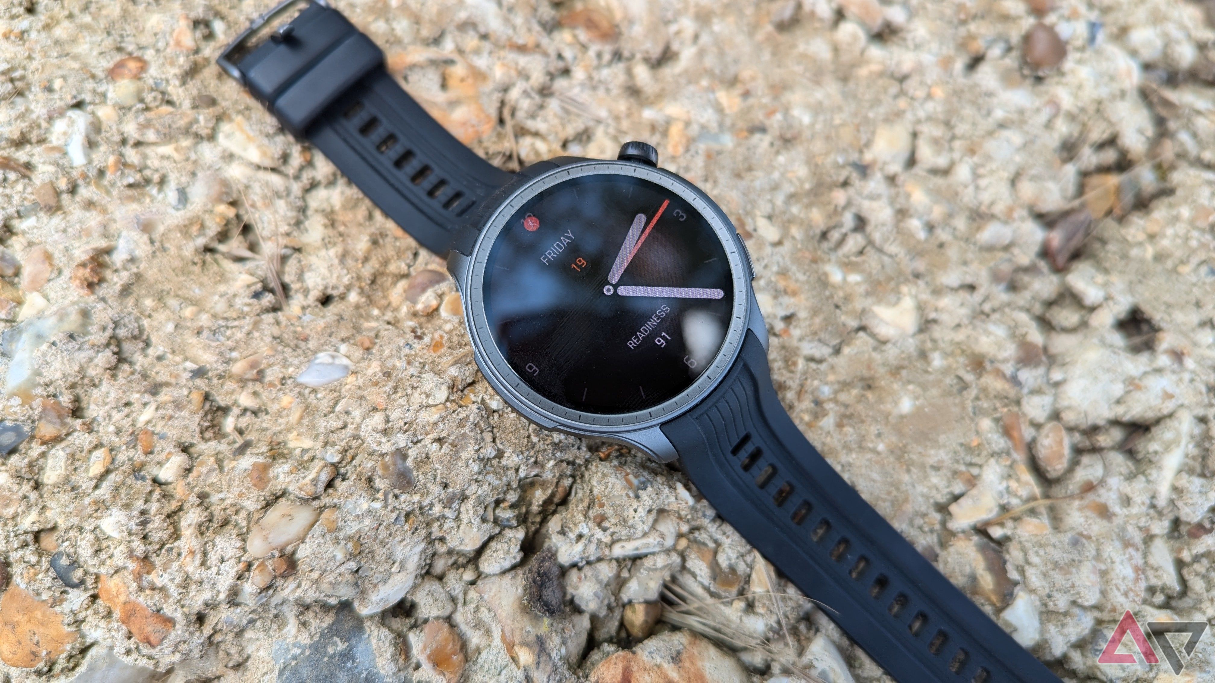 Smartwatch Amazfit Balance na cor Midnight colocado em superfície rochosa