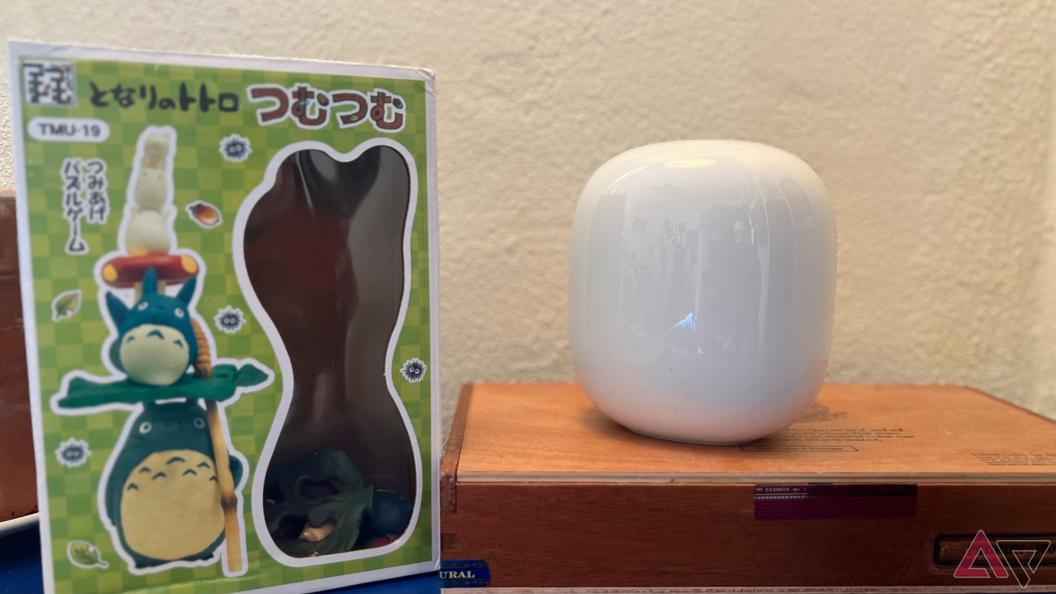 Google Nest Wifi Pro em caixa de cedro ao lado do brinquedo Totoro