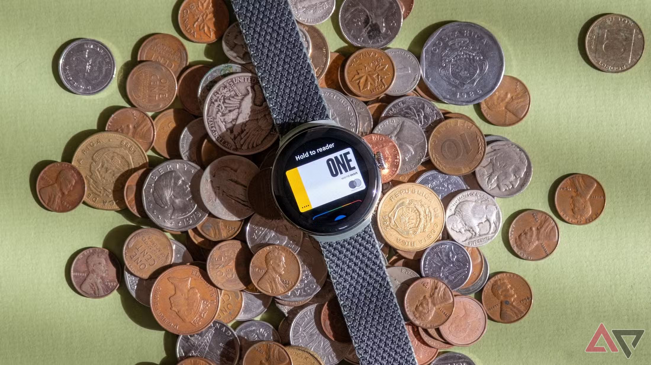 Um pixel Watch executando a Google Wallet. O Relógio está apoiado sobre uma pilha de moedas sobre uma mesa. 