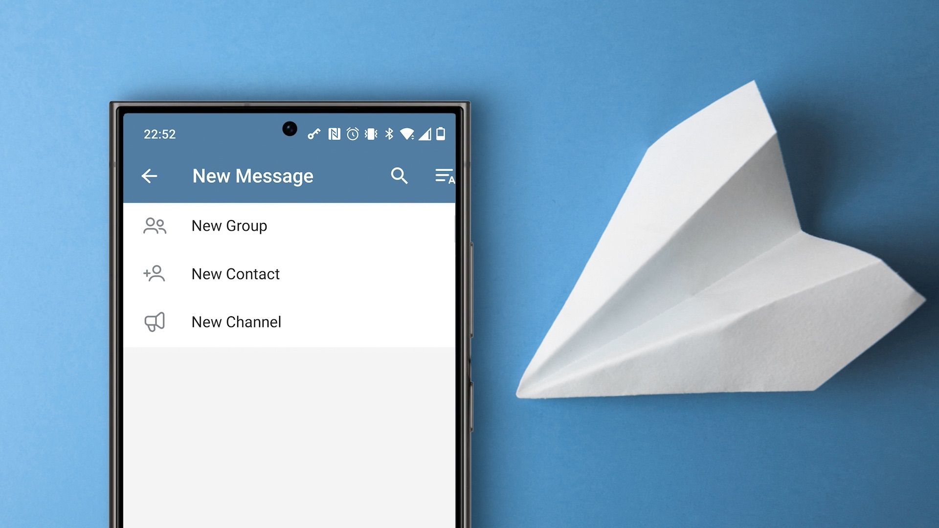 Smartphone ao lado de avião de papel com opções de criação de grupos do Telegram no display