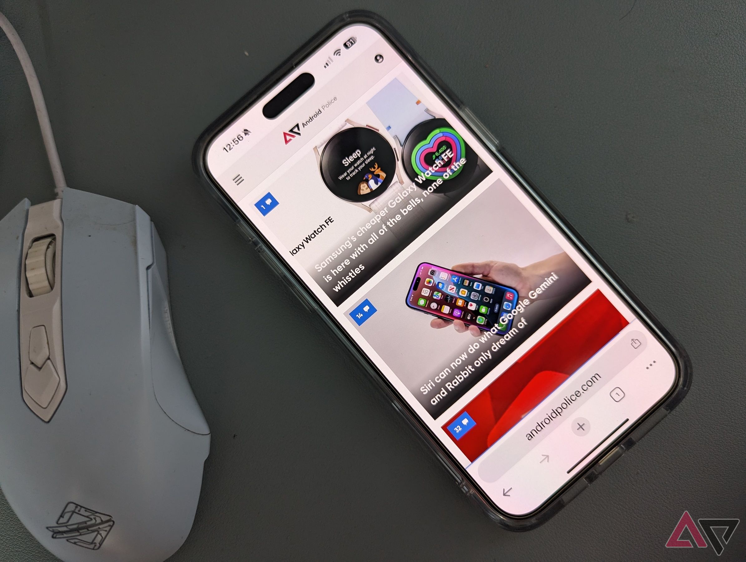 Google Chrome em um iPhone 15 Pro Max colocado em uma mesa ao lado de um mouse, mostrando a barra de ferramentas inferior